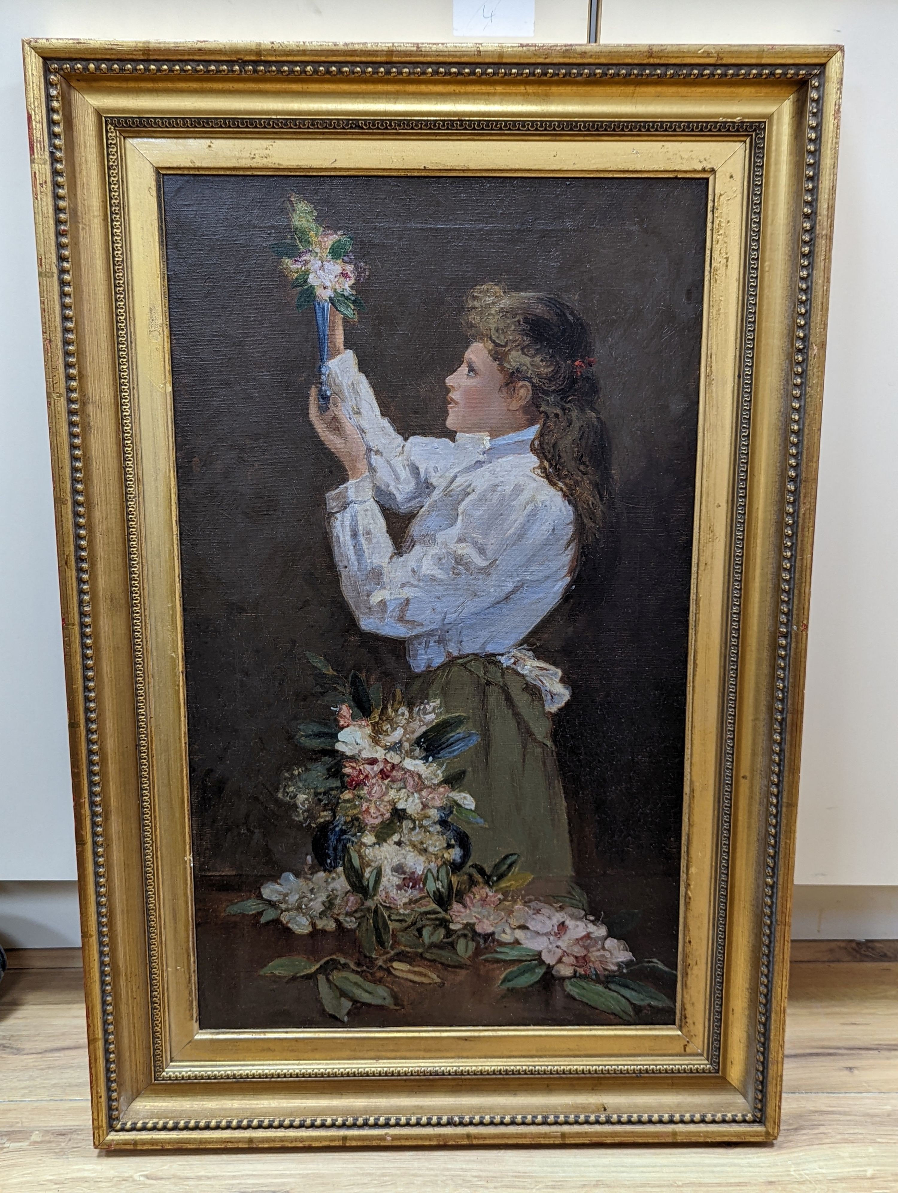 English School, circa 1900, oil on canvas, Young woman arranging flowers, 60 x 35cm
